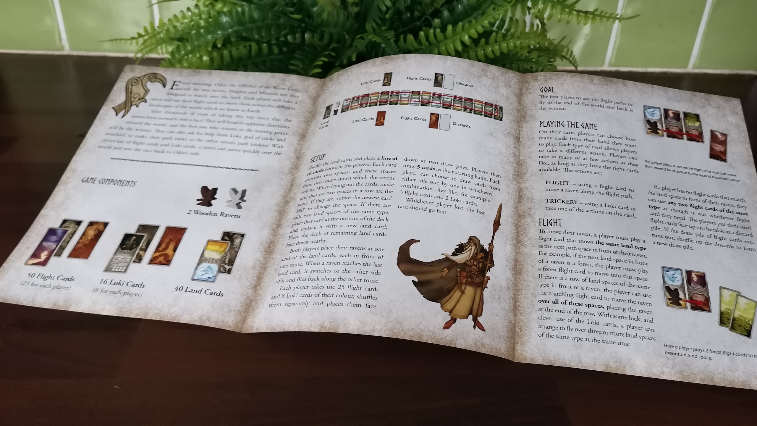 Odin's Ravens rulebook laid out on a wooden surface