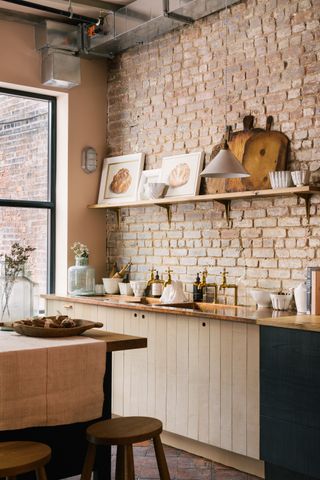 a kitchen with a brick wall backsplash