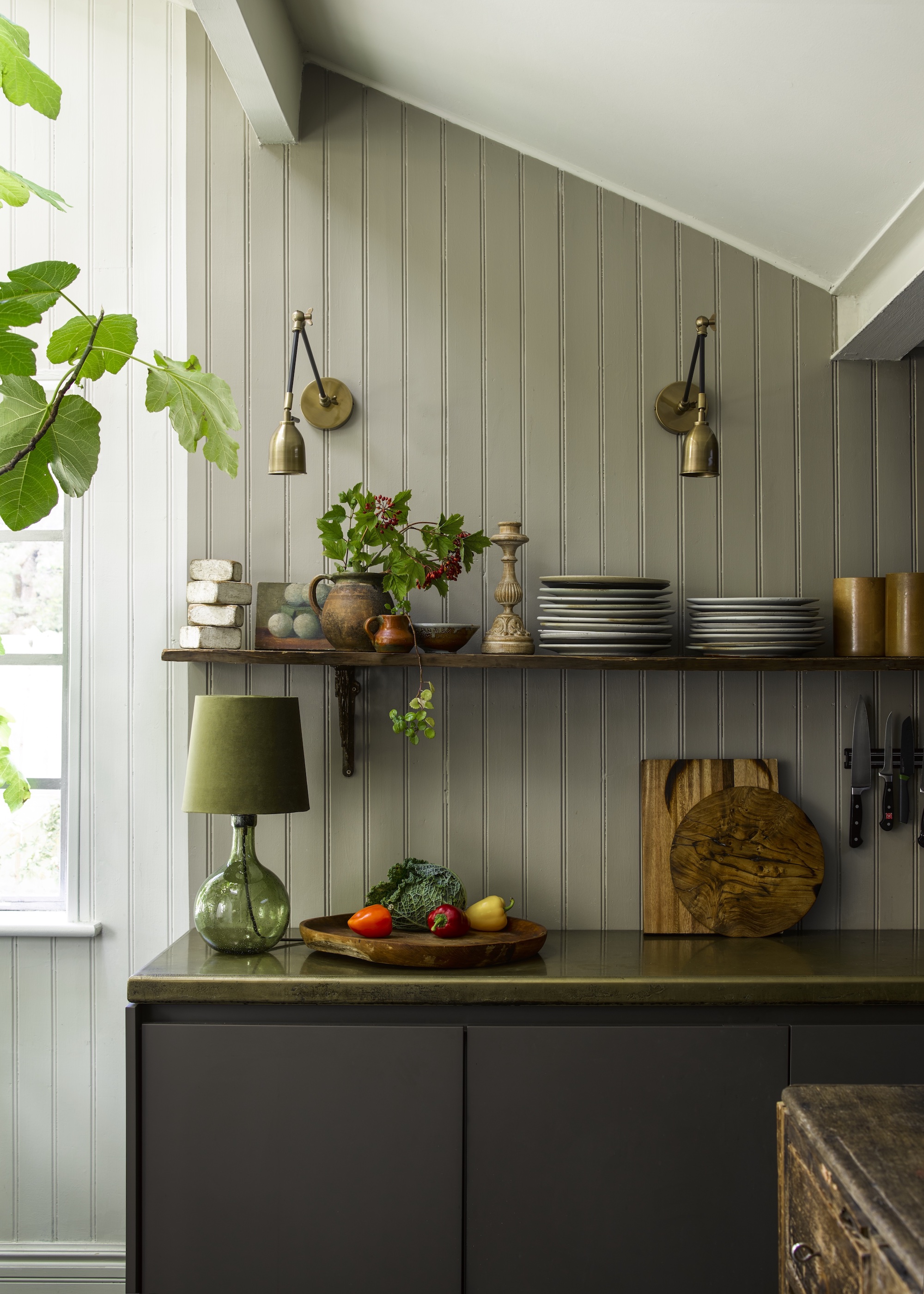 kitchen with beadboard walls and one shelf, two wall lights and a lamp