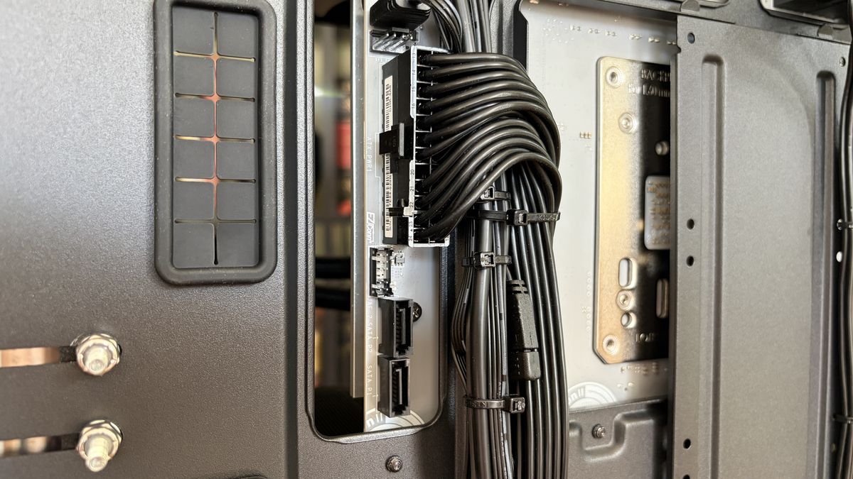 Close-up of a sleek MG-1 MK.II computer case interior showcasing organized black cables connected to a hub. The tone is technical and tidy, emphasizing precision.