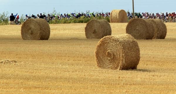 Riders appear dwarfed by giant hay bails