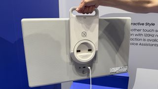 Samsung's The Movingstyle TV shown from the rear, being held up my a man's arm