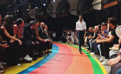 Male model on the runway modeling a white shirt and trousers from the Paul Smith S/S 2017 collection