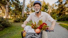 senior man on bike with a basket of healthy foods 
