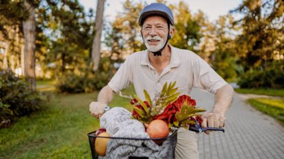 senior man on bike with a basket of healthy foods