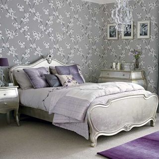 bedroom with wallpaper on wall and side table
