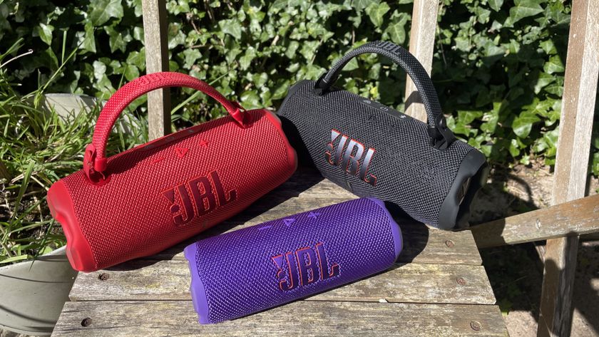 Two JBL Charge 6 speakers and one Flip 7 speaker grouped together on garden chair