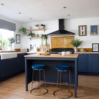 kitchen with white wall and wooden flooring and breakfast bar