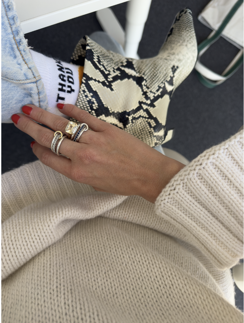 hand with rings and snakeskin boots