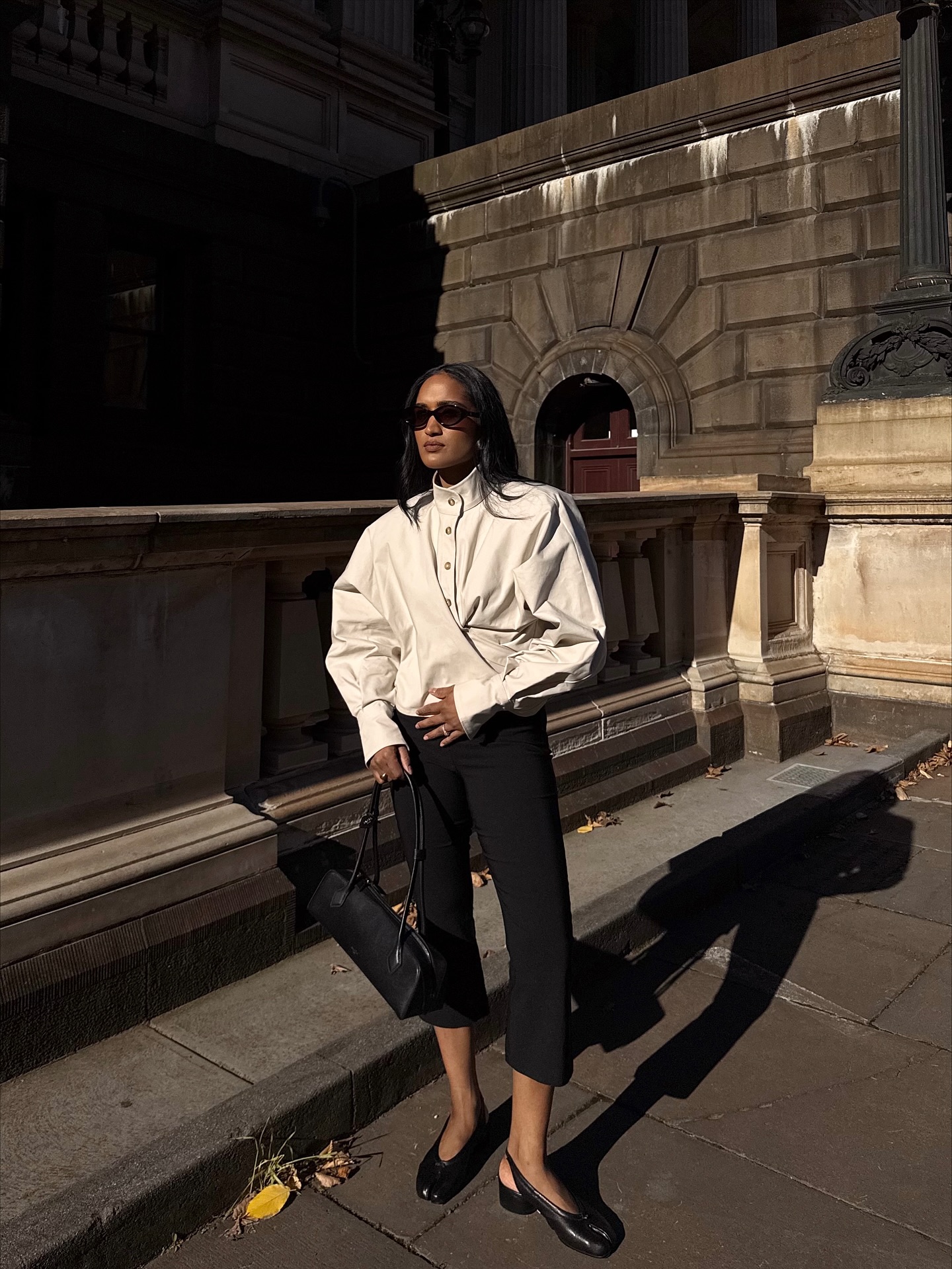 Influencer Div Ravindran wearing an anti-trend outfit of funnel neck jacket, cropped trousers and slingbacks.