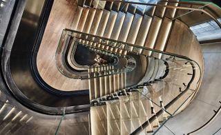 An undulating glass staircase runs through Bottega Veneta’s minimalist five-storey boutique