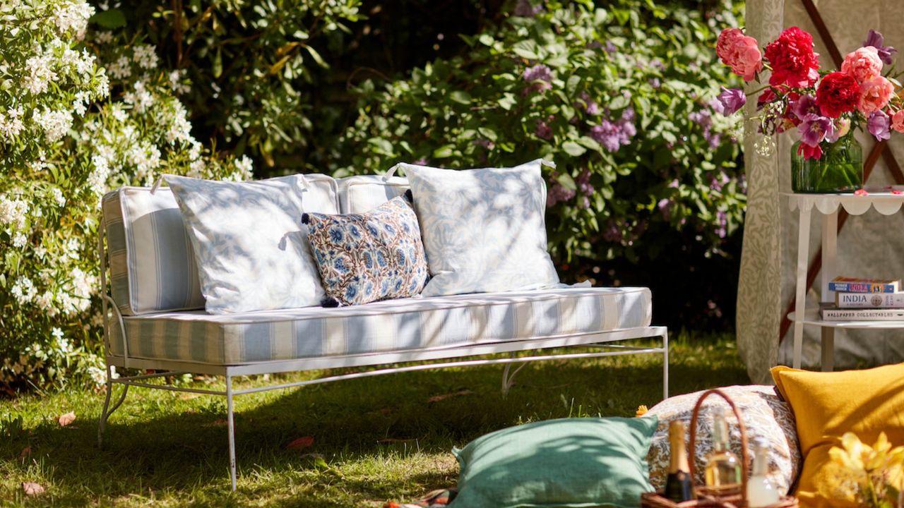 A white metal outdoor sofa with outdoor scatter cushions 