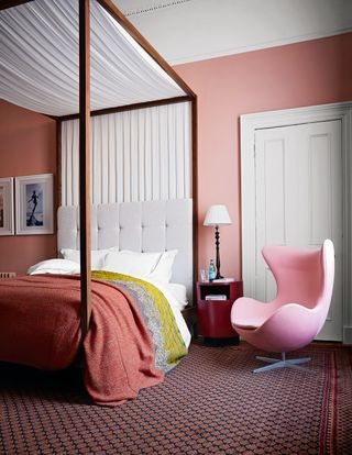 Pink bedroom with four poster bed and Egg chair