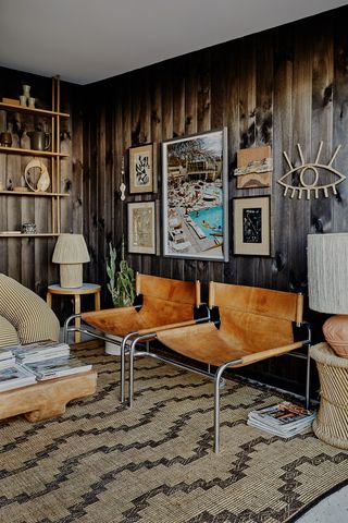 mid century chairs in a living room with wood cladding on the walls