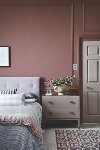 bedroom with painted walls and door in same raspberry paint shade