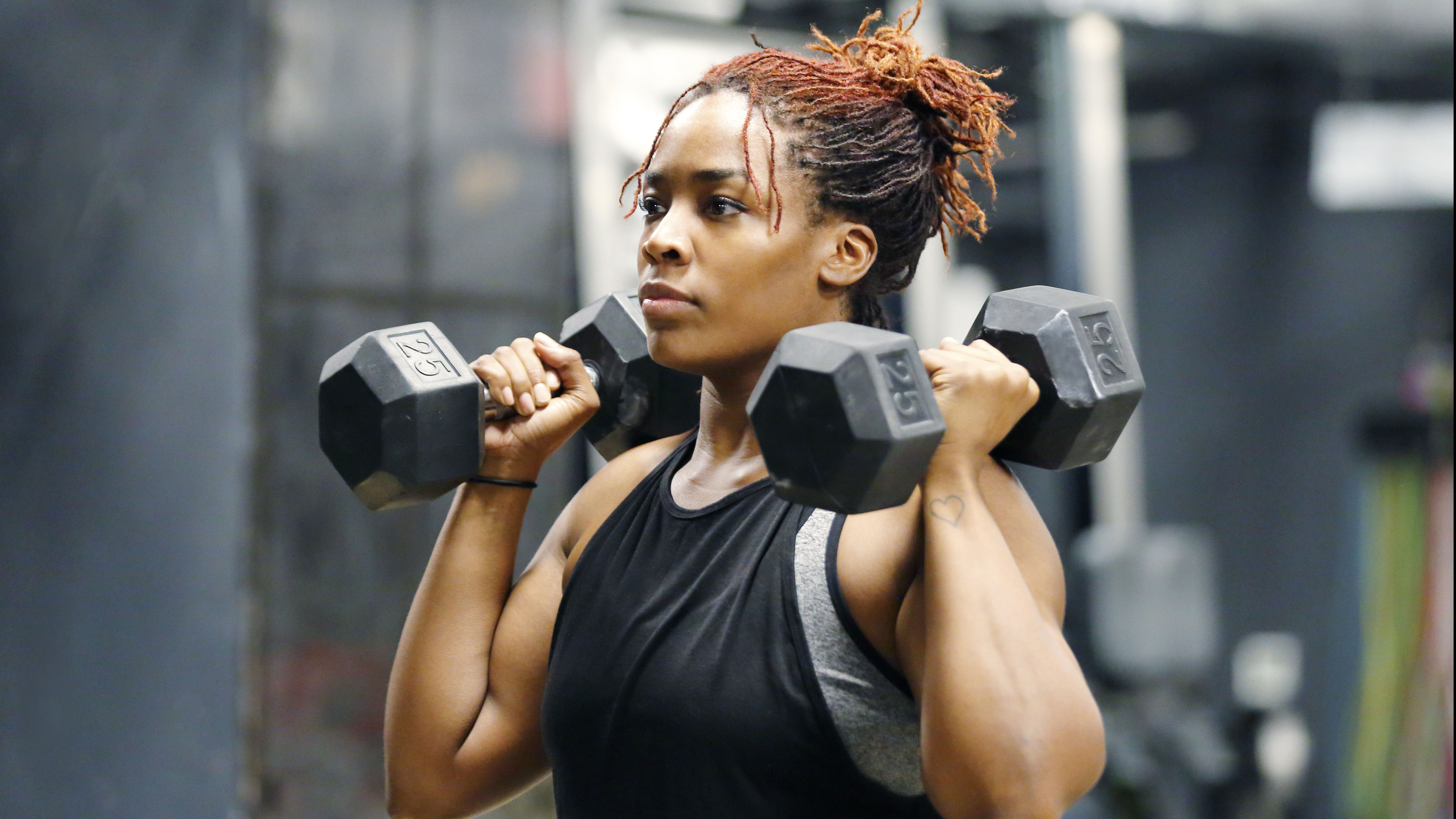 A woman lifts weights in the gym