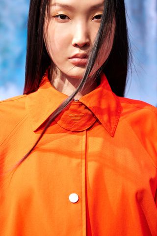 Woman in orange Emporio Armani jacket