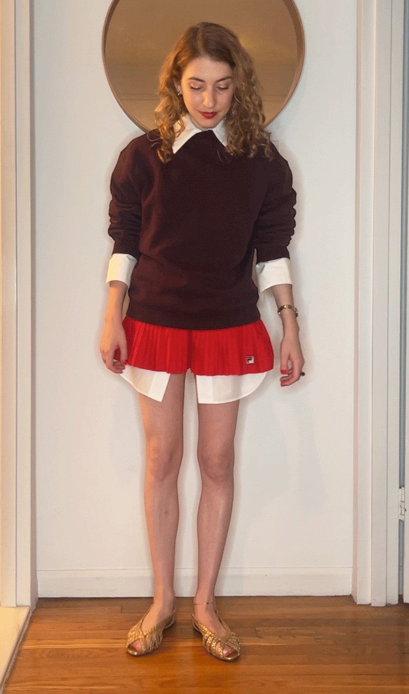 Elizabeth Cardinal Tamkin styling a brown sweatshirt, a red and white pair of shorts, and flats.