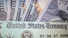 Photo of stimulus check in front of U.S. currency