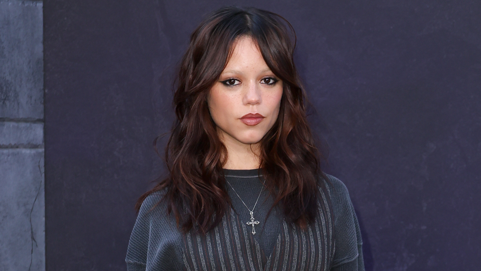 Jenna Ortega attended a Wednesday event in a pinstripe suit set layered over an oversize long-sleeve