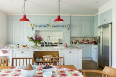 colourful family kitchen with kitchen island and table dressed in floral tablecloth