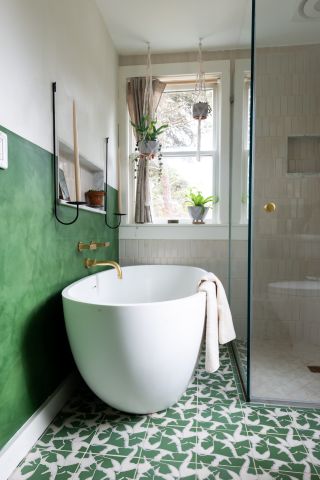 Green bathroom with freestanding tub and broken green patterned floor tiles