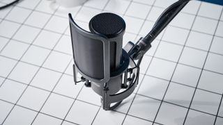 the Shure sm4 condenser musician microphone photographed against a blue background with a physical magnetic pop filter