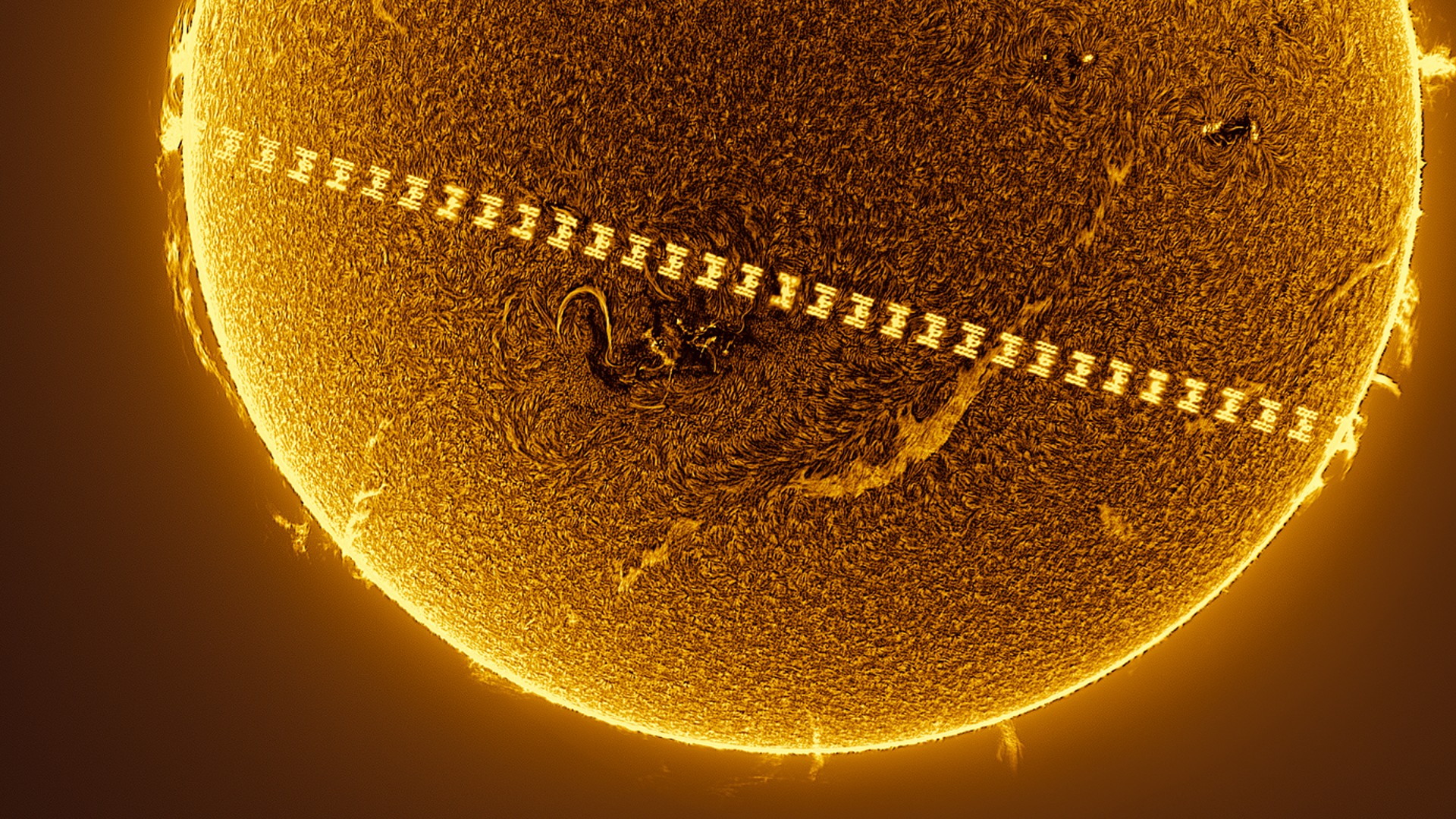 a t-shaped space station passes in front of a fiery sun