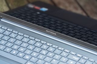 A black ASUS Zenbook 15 OLED laptop sitting on a table