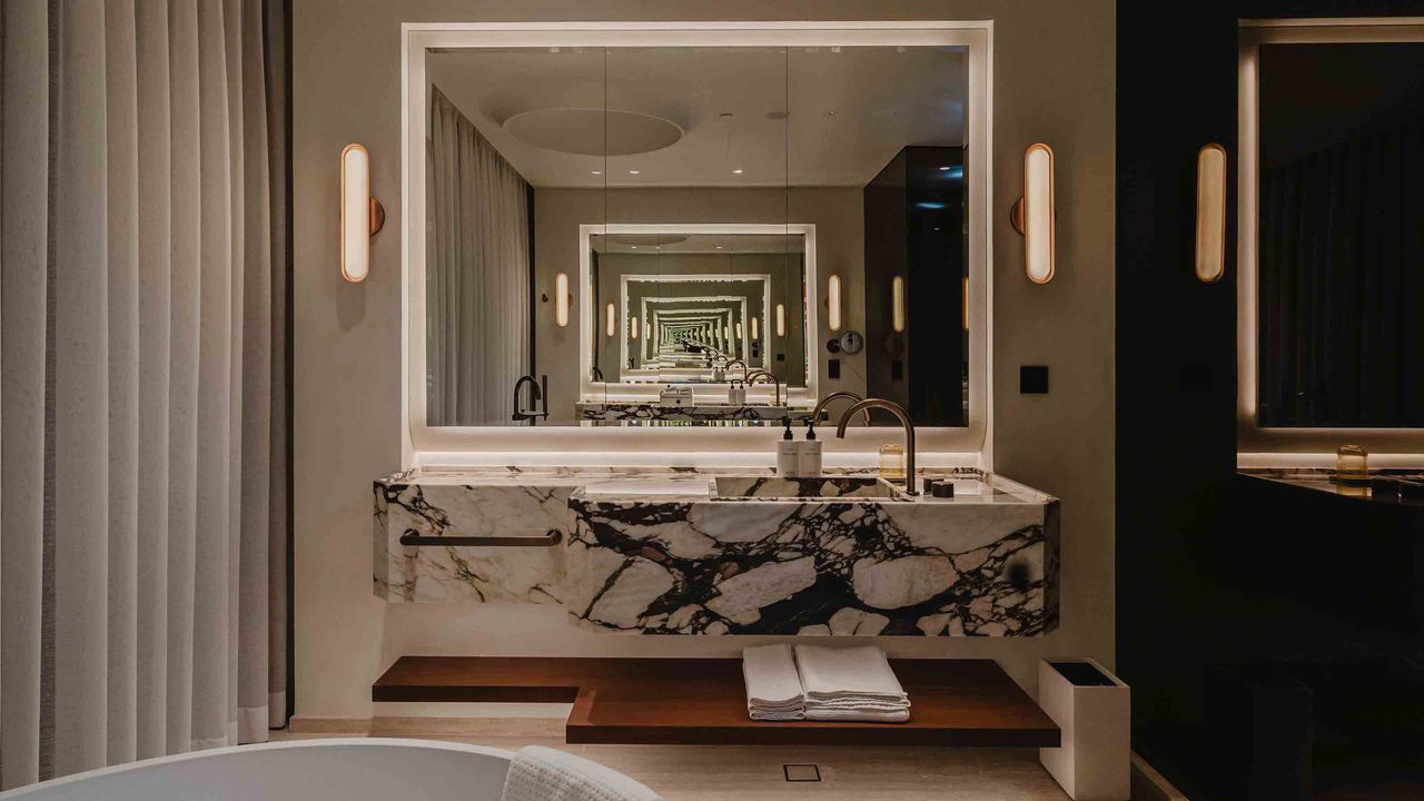 bathroom with marble wall hung vanity and infinity mirrors
