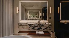 bathroom with marble wall hung vanity and infinity mirrors