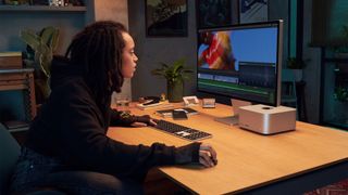 A lady using a Mac studio at a desk