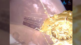 A closeup shot of the golden Tianwen 1 and its solar array and science antennae above Mars' north pole.