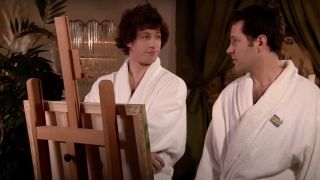 Andy Samberg and Paul Rudd looking at each other in bathrooms while standing next to an easel in an SNL digital short called "Everyone's a Critic."