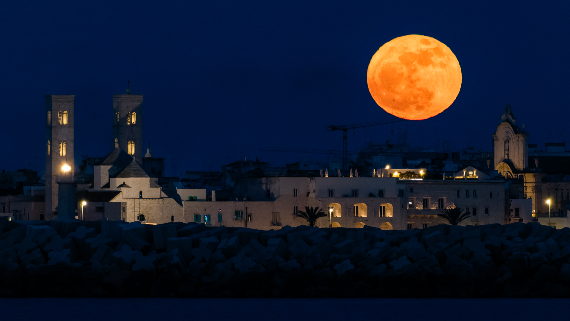 The May 12 full Flower Moon is pictured in a dark blue sky above the Molfetta Cathedral in Italy.