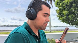 Listing image for cheap noise-cancelling headphones showing Anker Soundcore Space Q45 worn by reviewer assessing ANC 
