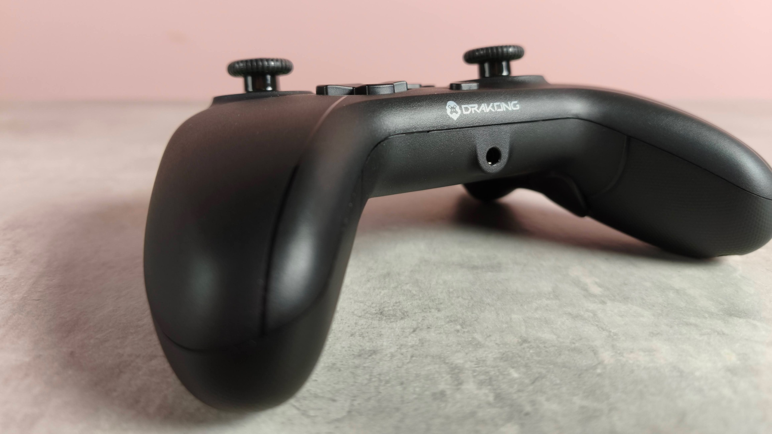 Close-up of headset jack on Drakong Challenger on a desk with pink wall in background