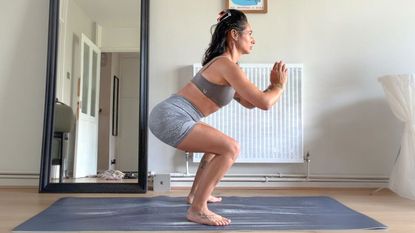 Sam performing squat at home on yoga mat