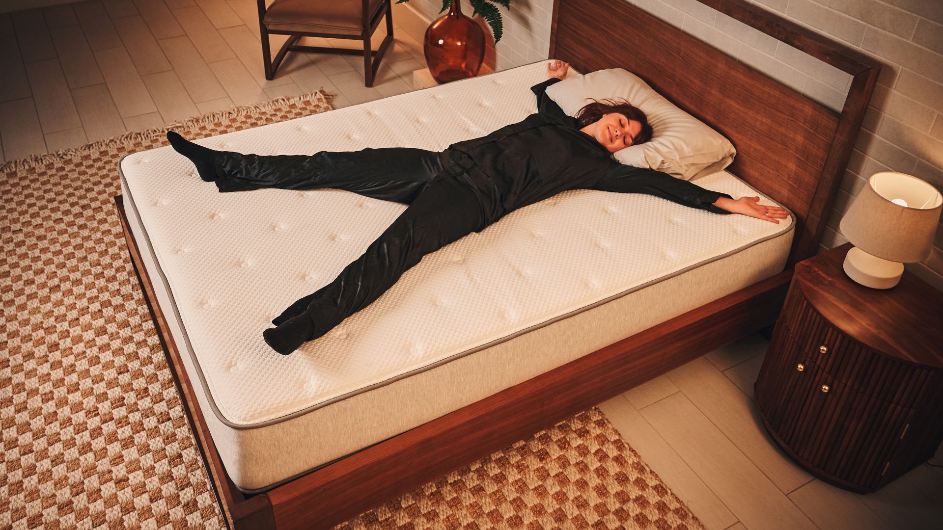 The Tom's Guide Sleep Features Editor lying in a starfish position on a mattress and smiling