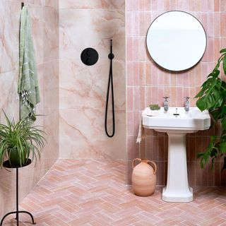Pink bathroom with chevron pink floor tiles and vertical pink subway wall tiles