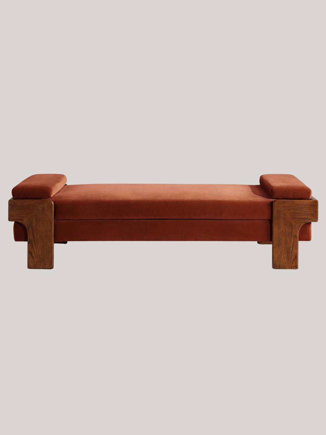 A rust velvet daybed with a wood frame from Soho Home