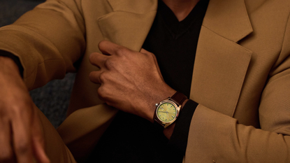 The Bulova Surveyor in pistachio worn by a person in a yellow suit