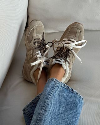 Influencer wears beige trainers.