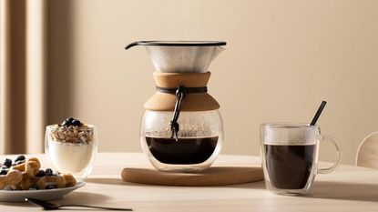 Bodum Pour over making coffee on a table with coffee and food around it