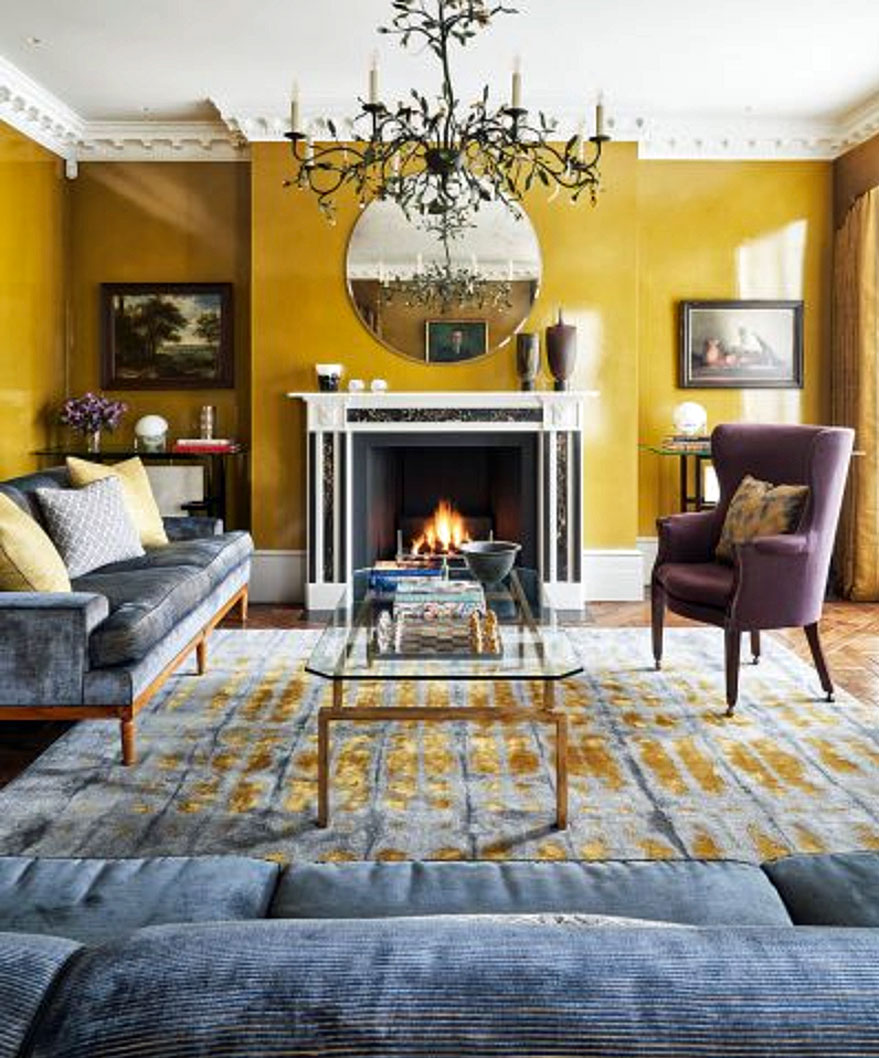 Living room color schemes illustrated in a yellow painted room with large chandelier and blue sofas.