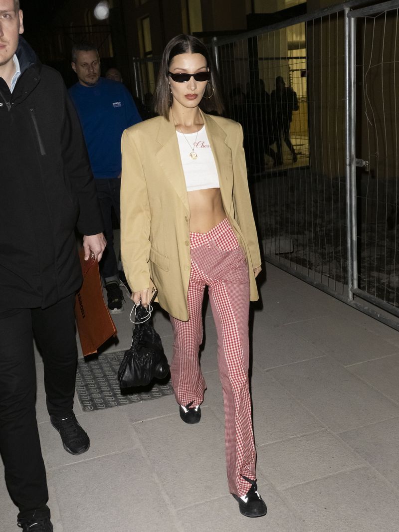 Bella Hadid in black bomber jacket with cherry print duffel bag in Milan on  January 13 ~ I want her style - What celebrities wore and where to buy it.  Celebrity Style