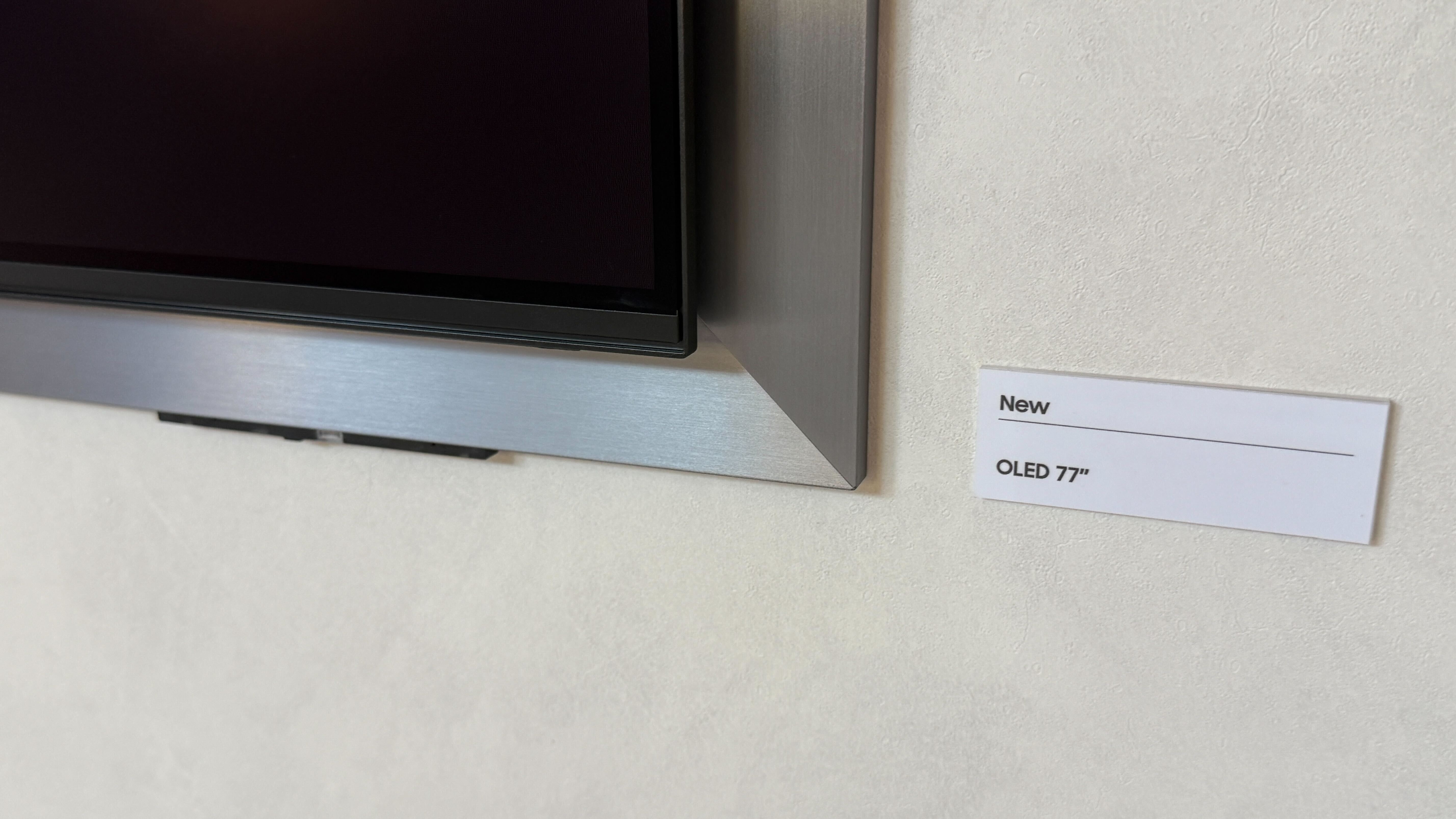 A wall mounted Samsung S95H showing stock footage of Las Vegas at night time