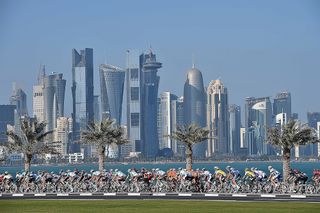 The peloton in action with Doha City in the background