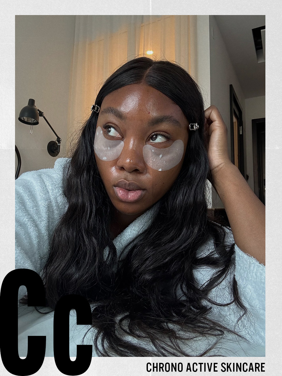 A woman wearing under-eye patches and a white robe taking a selfie