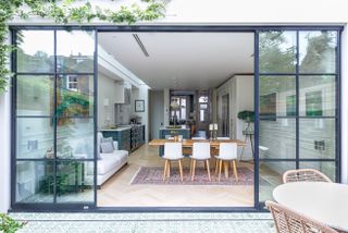 Modern kitchen ideas featuring a kitchen extension with crittall doors, wooden flooring and a vintage rug.